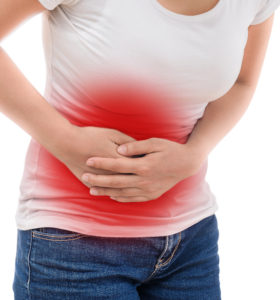 Young casual woman is having stomach ache.
